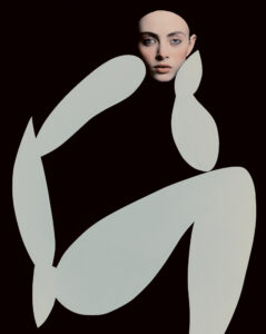 A portrait reveals a serene face set against a black backdrop, framed by abstract, large white shapes, resembling elongated ovals. These shapes intersect and intertwine, creating an impression of movement and fluidity. The face appears contemplative, with soft lighting highlighting delicate features, while the simple, contrasting colors add a modern, artistic touch to the overall composition.