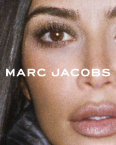 A close-up of a person's face showcases one eye and partial lips. The eye has pronounced lashes and a well-defined brow. The makeup is meticulous, highlighting the contour and soft tones of the skin. The lips appear full and slightly parted. The hair, dark and glossy, frames part of the visible face.