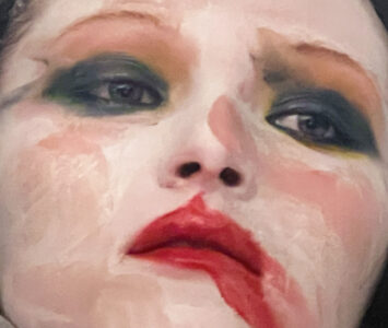 A dramatic portrayal features a face with striking, theatrical makeup. Dark eyeshadow accentuates expressive eyes while bold red lipstick, slightly smudged, adds intensity to the lips. The facial expression is evocative, hinting at deep emotion or contemplation. Soft lighting enhances the vividness of the colors, emphasizing the artistic and emotive aspects of the portrayal.