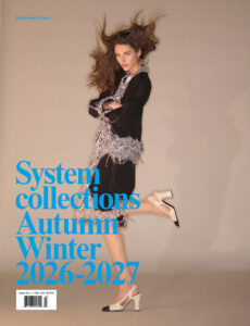 A model dynamically poses in a motion-filled stance against a neutral backdrop. Her hair is tousled, creating a windswept effect. She wears an elegant outfit with silver embellishments and classic black accents. Her ensemble is complemented by chic, two-tone high-heeled shoes. The overall look exudes a stylish, edgy vibe with a modern and sophisticated twist.